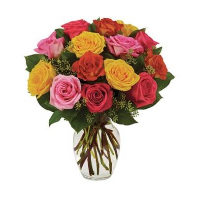 Mixed roses in pink, yellow, and orange arranged in a clear glass vase