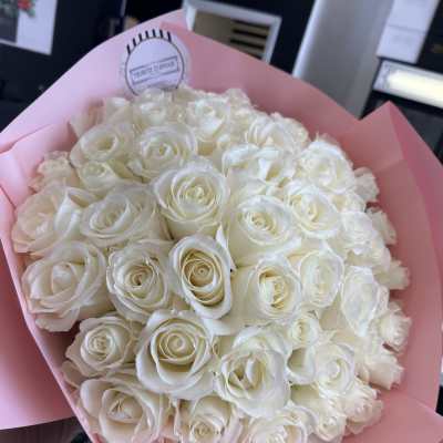 Bouquet of white roses wrapped in pink paper