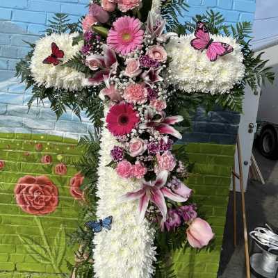 Large floral cross with pink and white flowers and butterfly accents