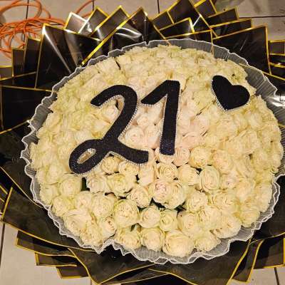 Round bouquet of cream roses with a black "21" topper