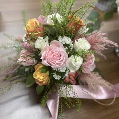 Bouquet of pink, white, and peach roses with ribbon wrap