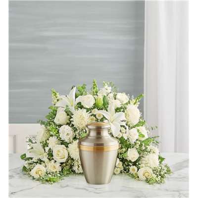 White floral funeral arrangement with an urn in front