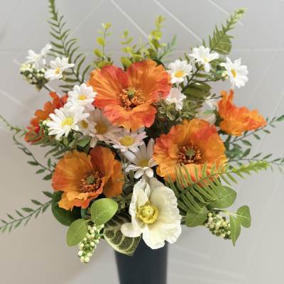 Orange and white flowers arranged in a tall black vase