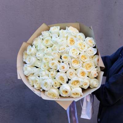 Bouquet of white roses wrapped in tan paper