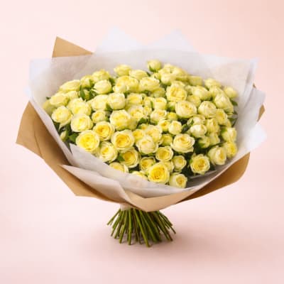 Bouquet of pale yellow roses wrapped in white and brown paper
