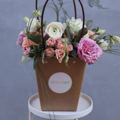 Basket arrangement with pink and white flowers and tall looping stems