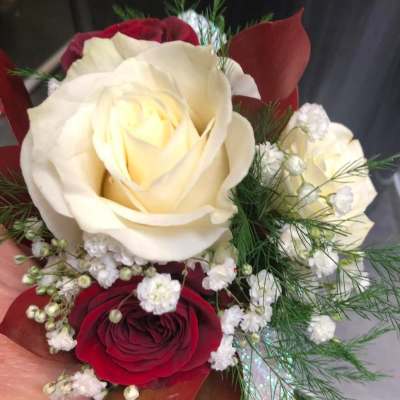 Handheld bouquet of red and white roses with baby's breath