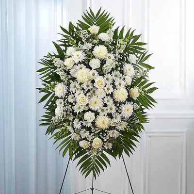 White funeral spray with daisies and roses on an easel