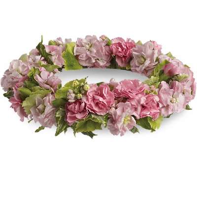 Low circular wreath of pink flowers and buds forming a ring on a white background