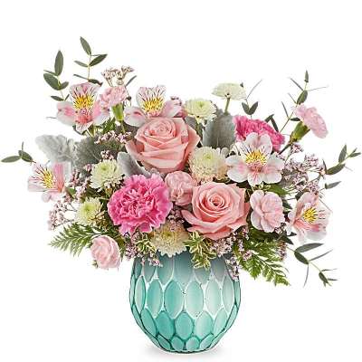 Pink roses, carnations, and white mums arranged in a teal textured glass vase