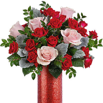 Tall arrangement of red and light pink roses in a glittery red cylinder vase