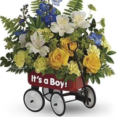 Yellow roses, white alstroemeria, and blue flowers arranged in a red 'It’s a Boy!' toy wagon