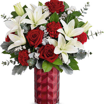 Tall red vase arrangement with white lilies, red roses, and red carnations.
