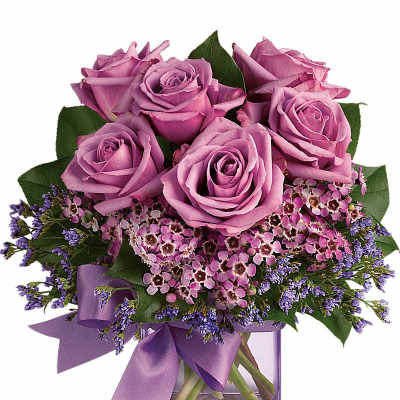 Lavender roses and small pink blossoms arranged in a purple glass cube vase with a matching ribbon