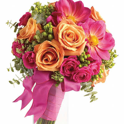 Hand-tied bouquet of peach roses and hot pink flowers wrapped in pink ribbon in a clear vase.