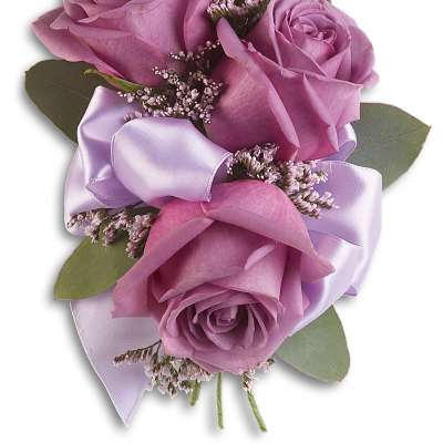 Small corsage with three lavender roses, tiny filler flowers, and a lavender satin bow.