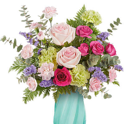 Mixed bouquet of pink roses, green carnations and purple filler in a teal glass vase