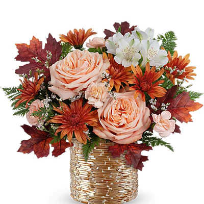 Autumn arrangement with peach roses, orange mums, and white blooms in a gold textured cylinder vase
