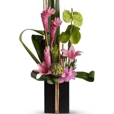 Tall modern arrangement with pink lilies and tropical blooms in a black rectangular vase