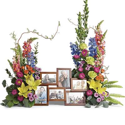 Colorful twin floral sprays with yellow lilies and mixed blooms framing a wooden multi-photo frame display