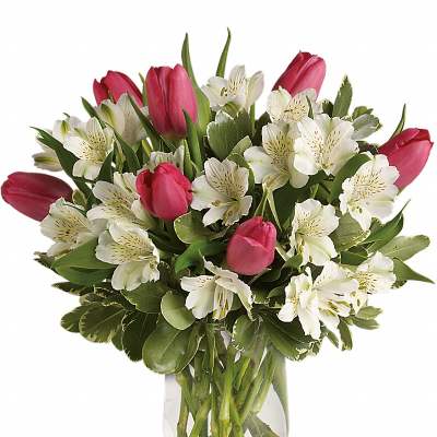 Arrangement of pink tulips and white alstroemeria in a clear glass vase