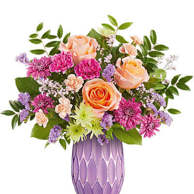 Arrangement of peach roses and mixed pink and purple flowers in a tall lavender vase