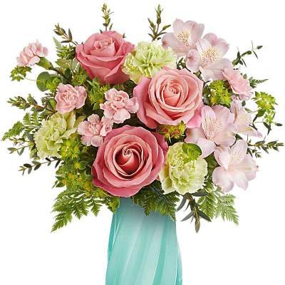 Pastel pink roses, green carnations, and pink alstroemeria in a teal glass vase