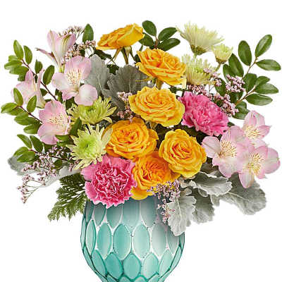 Mixed bouquet of yellow roses, pink carnations, and pastel blooms in a teal patterned ceramic vase