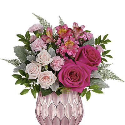 Pink and blush roses, carnations, and alstroemeria arranged in a pink textured glass vase