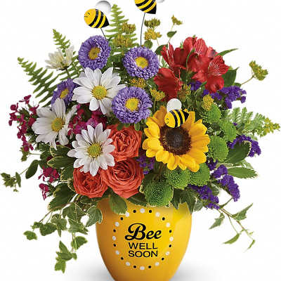 Bright mixed flower arrangement with bees in a yellow Bee Well Soon vase