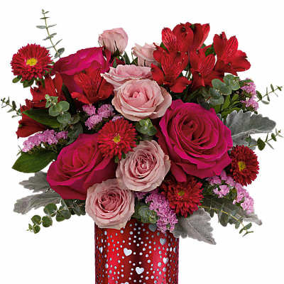 Red and pink mixed flower arrangement in a red cylinder vase with heart cutouts