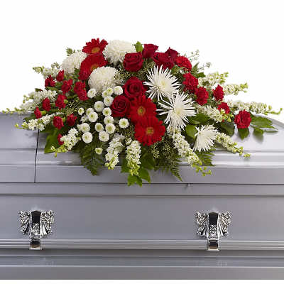 Red and white casket spray with roses, daisies, carnations, and mums on a gray casket
