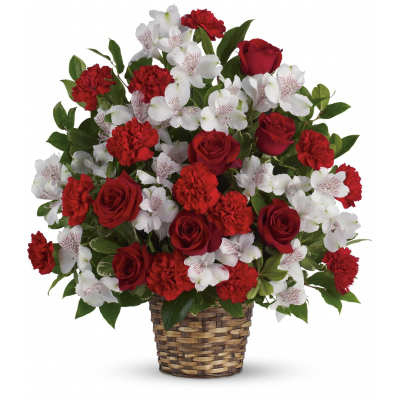 Red roses, red carnations, and white alstroemeria arranged in a woven basket