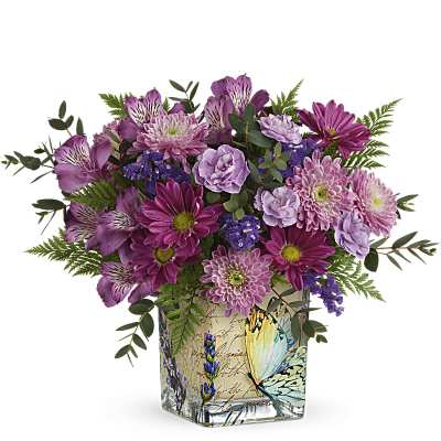 Purple and pink mixed bouquet in a square glass vase with a butterfly design