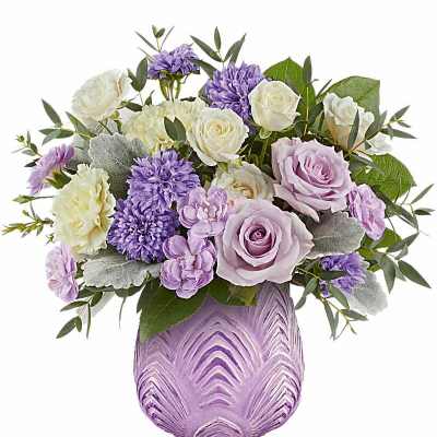 Lavender and white roses, carnations, and mums arranged in a textured lavender vase