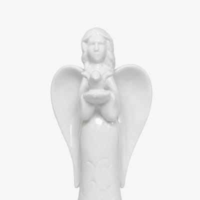 White ceramic angel figurine holding a small bird