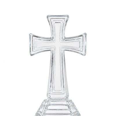 Clear glass cross-shaped decorative stand on a white background