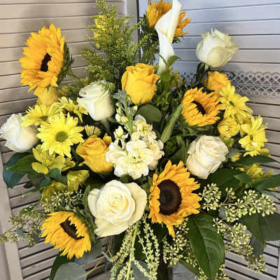 Bouquet of yellow sunflowers and white roses in a glass vase