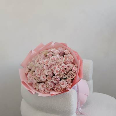Bouquet of pale pink roses wrapped in pink paper