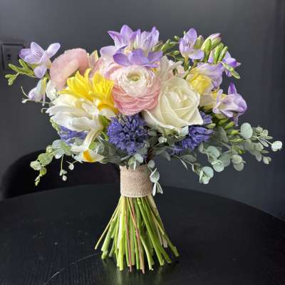 Wedding bouquet with pastel flowers and eucalyptus wrapped in burlap