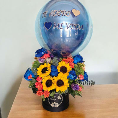 Blue balloon over a colorful flower arrangement in a black box