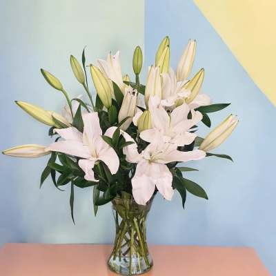 White lilies arranged in a clear glass vase