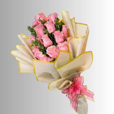 Bouquet of pink roses wrapped in cream paper with yellow trim