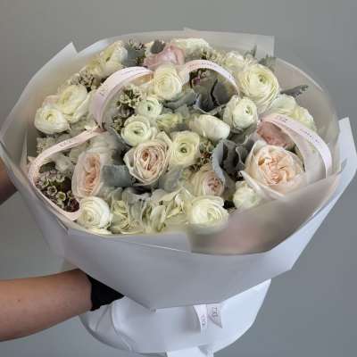Bouquet of pale pink and white roses with ribbon accents