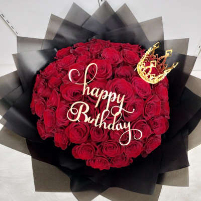 Red rose bouquet with a gold "Happy Birthday" topper and crown
