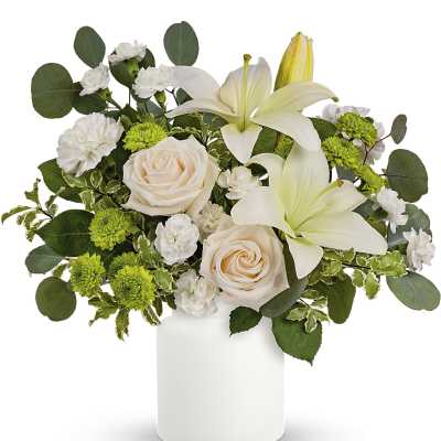 White lilies and pale roses in a white vase with green accents