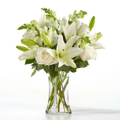 White lilies and roses in a clear glass vase