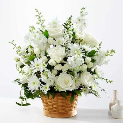White roses and daisies arranged in a woven basket