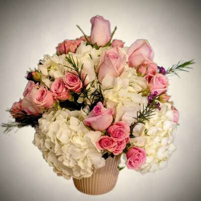 Pink roses and white hydrangeas arranged in a ribbed vase