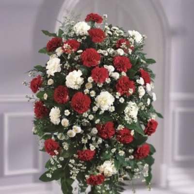Standing spray of red and white carnations with white daisies on a metal easel